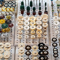 Verschiedenfarbige Polierscheiben und Bürstchen für zahntechnische Anwendungen sind bei der zahntechnikplus geordnet in Steckhalterungen ausgestellt.